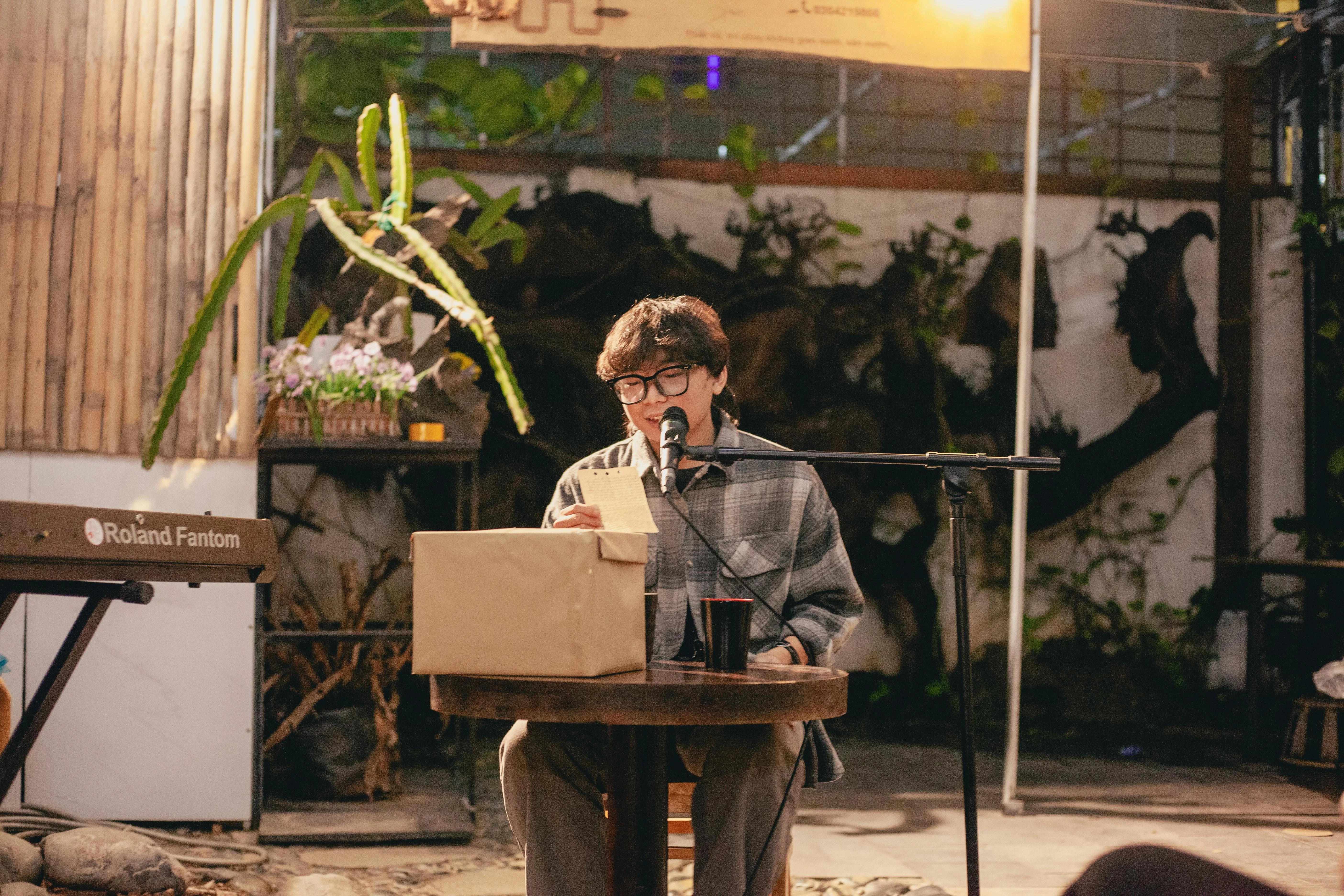 Person performing at café with Roland keyboard