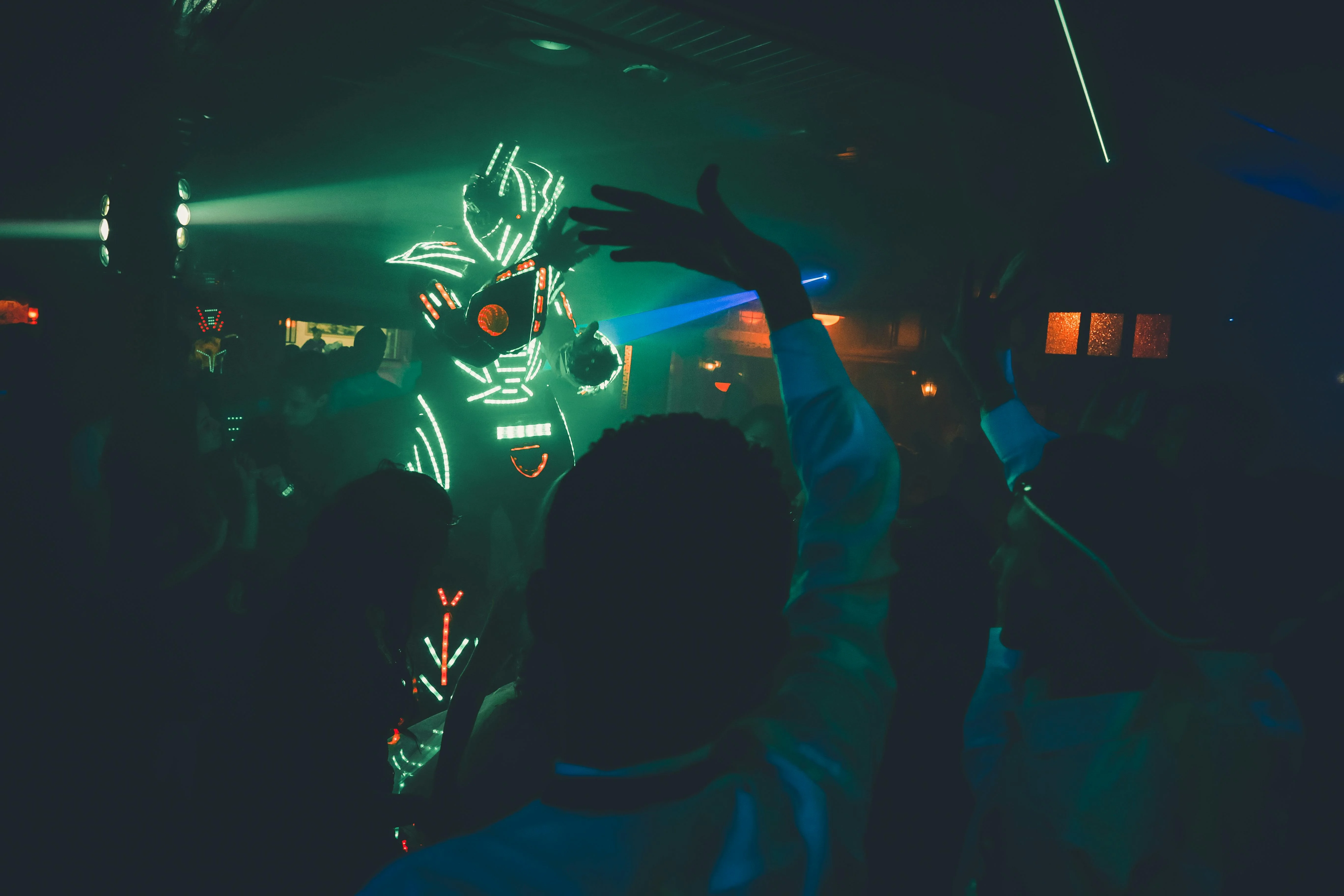 LED robot costume performer in night club crowd